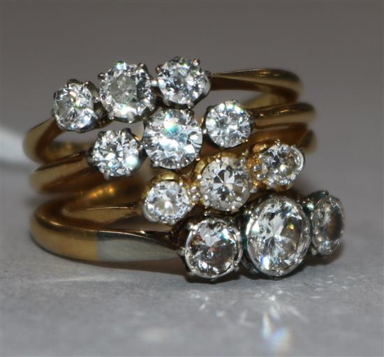Four assorted 18ct gold and three stone diamond rings.